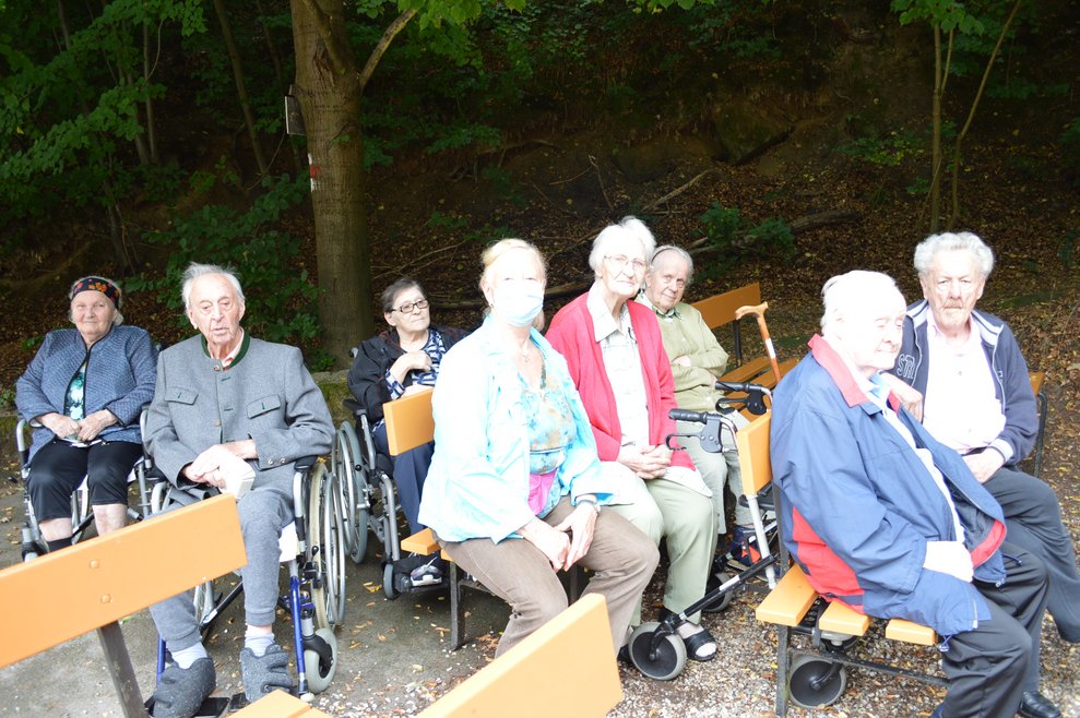 BewohnerInnen sitzen draußen.