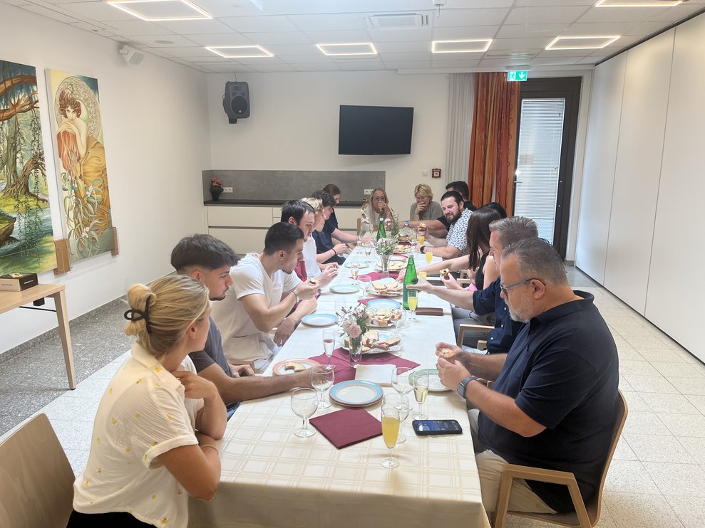 Großer Tisch mit vielen Personen