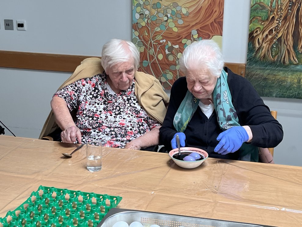 Zwei Bewohnerinnen färben Ostereier