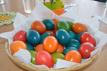 Gefärbte Eier liegen in einem Korb.