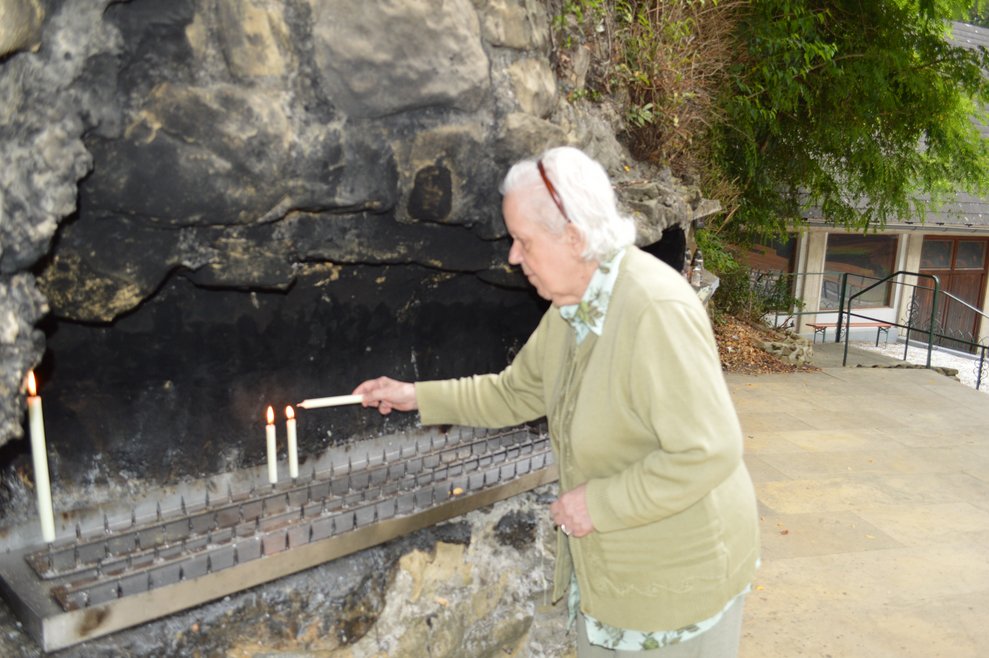 Eine Bewohnerin zündet eine Kerze an.